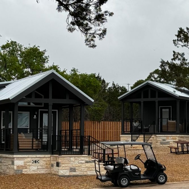 exterior view of luxury Cabins amongst trees and grass