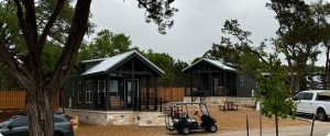 exterior view of luxury Cabins amongst trees and grass